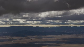 AF0001_001018 - 8K aerial stock footage of thick clouds over desert and mountain ridges in Southern California