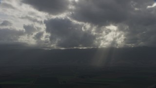 AF0001_001025 - 8K aerial stock footage of godrays shining down on farm fields in Southern California