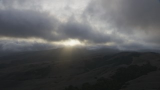 AF0001_001027 - 8K aerial stock footage of thick clouds over rolling hills at sunset in Southern California