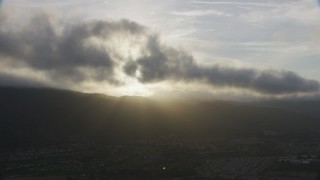 AF0001_001028 - 8K aerial stock footage of thick clouds over mountains and suburban homes at sunset in Southern California