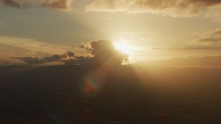 AF0001_001032 - 8K aerial stock footage of setting sun behind clouds as a helicopter passes in Southern California