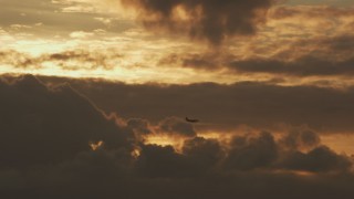 AF0001_001037 - 8K aerial stock footage track an airliner descending from the clouds at sunset in Northern California