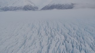 AK0001_0027 - 4K aerial stock footage fly over Knik Glacier,  Chugach Mountains, low clouds, Knik Glacier, Alaska
