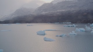 AK0001_0044 - 4K aerial stock footage shoreline, reveal icebergs, snow covered mountains, Inner Lake George, Alaska