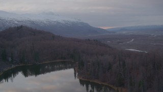 AK0001_0064 - 4K aerial stock footage over foothills, reveal lake, valley, Chugach Mountains, Knik River Valley, Alaska