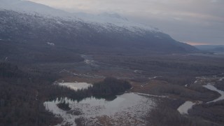 AK0001_0066 - 4K aerial stock footage fly by rivers, Chugach Mountains, tilt down to small lake, Knik River Valley, Alaska