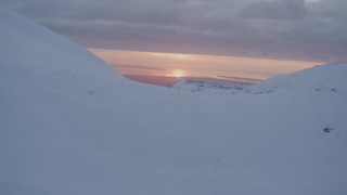 AK0001_0090 - 4K stock footage aerial video approach snow covered summit, reveal sunset, Chugach Mountains, Alaska, sunset
