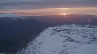 AK0001_0092 - 4K stock footage aerial video snowy slope, reveal Alpenglow at Arctic Valley, Chugach Mountains, Alaska, sunset