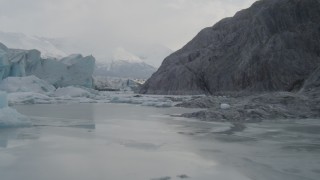 AK0001_0116 - 4K aerial stock footage flying low over icy Knik River, tilt up, revealing Knik Glacier, Alaska