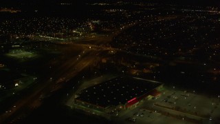 AK0001_0198 - 4K aerial stock footage tilt up from intersection, following freeway and revealing Anchorage, Alaska, night