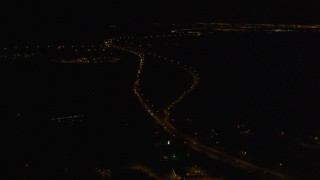 AK0001_0201 - 4K aerial stock footage flying along Glenn Highway, approaching Hiland Mountains Correctional Center, Eagle River, Alaska, night