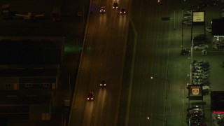 AK0001_0207 - 4K aerial stock footage following East 5th Avenue, tracking a police car, Anchorage, Alaska, night