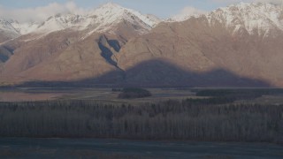 AK0001_0289 - 4K aerial stock footage tilting down over trees, revealing river and Swan Lake, Alaska