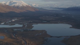 AK0001_0299 - 4K aerial stock footage flying over lakes and rivers, tilt up to reveal Knik River Valley, Alaska