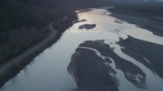 AK0001_0304 - 4K aerial stock footage tilting up from the river, Knik River, Alaska, sunset