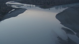 AK0001_0306 - 4K aerial stock footage following the Knik River past houses, forest, Knik River, Alaska, twilight