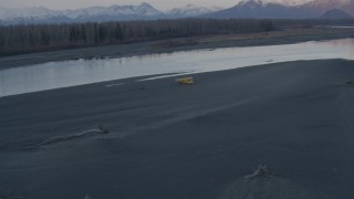 AK0001_0311 - 4K aerial stock footage orbiting a small plane readying for takeoff on the shore, Knik River, Alaska, sunset