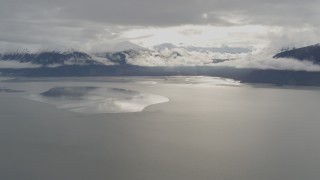 AK0001_0351 - 4K aerial stock footage snowy Kenai Mountains, sunlit clouds, the Turnagain Arm of the Cook Inlet, Alaska