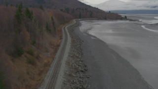 AK0001_0357 - 4K aerial stock footage follow railroad tracks along shore of Turnagain Arm of the Cook Inlet, Alaska