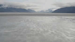 AK0001_0371 - 4K aerial stock footage flying low over the water, tilt up, revealing Turnagain Arm of the Cook Inlet, Alaska