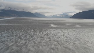 AK0001_0372 - 4K aerial stock footage flying low over water, tilt up, revealing Turnagain Arm of the Cook Inlet, Alaska