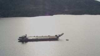 AK0001_0404 - 4K aerial stock footage approaching an anchored barge, reveal surrounding foothills, Shotgun Cove, Alaska