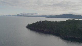 AK0001_0407 - 4K aerial stock footage flying out to open water, pan right to shoreline, Passage Canal, Alaska