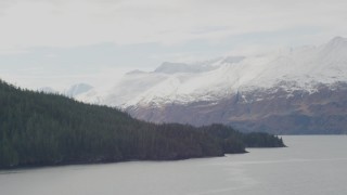 AK0001_0460 - 4K aerial stock footage rounding coast, glacier spilling down from mountains, Blackstone Bay, Alaska