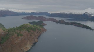 AK0001_0480 - 4K aerial stock footage flying by island, surrounded by snow capped mountains, Blackstone Bay, Alaska