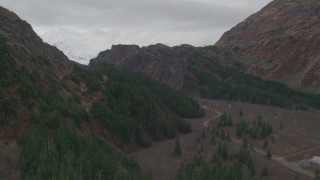 AK0001_0502 - 4K aerial stock footage flying beside country road, shallow creek, reveal pond and canyon, Whittier, Alaska