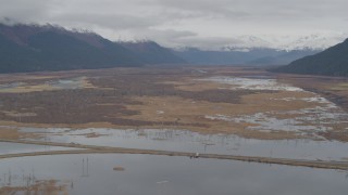 AK0001_0519 - 4K aerial stock footage flying by marshland valley beyond train tracks, Portage, Alaska