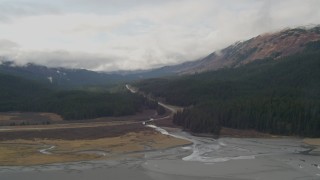 AK0001_0523 - 4K aerial stock footage flying by Seward Highway cutting through forest in the valley, Portage, Alaska