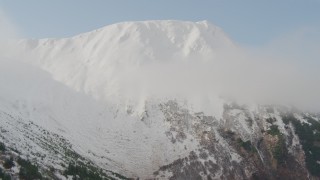 AK0001_0526 - 4K aerial stock footage ascending slope approaching snowy summit, Kenai Mountains, Alaska