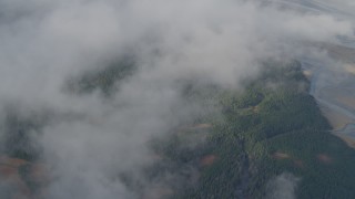 AK0001_0531 - 4K aerial stock footage bird's eye view over clouds, river valley, wooded foothills, Kenai Mountains, Alaska