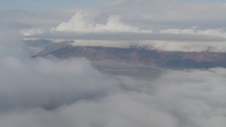 AK0001_0532 - 4K aerial stock footage fly by low clouds over Kenai Mountains, Turnagain Arm of the Cook Inlet, Alaska