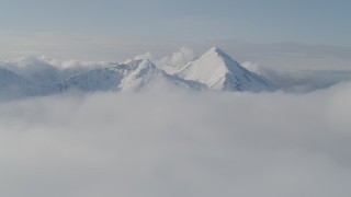 AK0001_0535 - 4K aerial stock footage flying by snow covered Kenai Mountains, low clouds, Kenai Mountains, Alaska