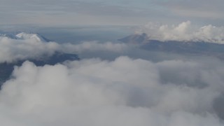 AK0001_0546 - 4K aerial stock footage pan by Chugach Mountains, low clouds, Turnagain Arm of the Cook Inlet, Alaska