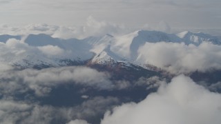 AK0001_0547 - 4K aerial stock footage flying by low clouds over valley bordered by the Kenai Mountains, Alaska