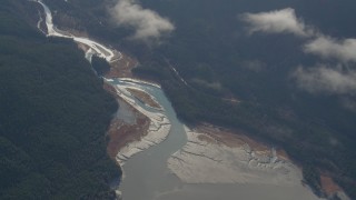 AK0001_0550 - 4K aerial stock footage flying by wooded river valley on the shore, Turnagain Arm of the Cook Inlet, Alaska