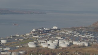 AK0001_0584 - 4K aerial stock footage large tanks and a cargo ship at the port, Anchorage, Alaska
