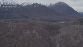 AK0001_0623 - 4K aerial stock footage flying over wooded hills, approaching Chugach Mountains, Birchwood, Alaska