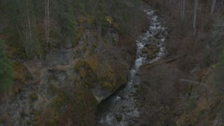AK0001_0632 - 4K aerial stock footage following river at bottom of gorge, reveal wooded hills, Birchwood, Alaska