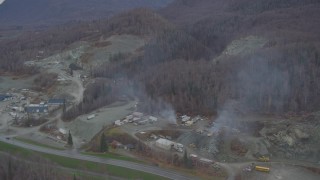 AK0001_0652 - 4K aerial stock footage flying away from a quarry, wooded hills, Chugiak, Alaska