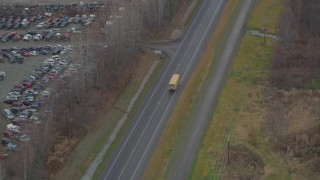 AK0001_0659 - 4K stock footage aerial video tracking school bus, Old Glenn Highway, past junkyard, Chugiak, Alaska