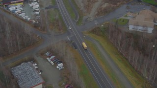 AK0001_0660 - 4K stock footage aerial video tracking, passing school bus on Old Glenn Highway, tilt up to reveal Chugiak, Alaska