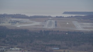 AK0001_0667 - 4K aerial stock footage tracking a military jet taking off, Elmendorf Air Force Base, Anchorage, Alaska