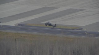 AK0001_0668 - 4K aerial stock footage military helicopter landing, 6 parked, Bryant Army Heliport, Anchorage, Alaska