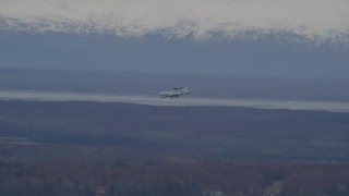 AK0001_0671 - 4K aerial stock footage tracking E-3 Sentry  landing, snowy mountains, Fort Richardson, Alaska