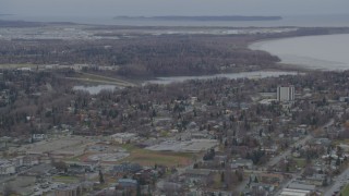 AK0001_0675 - 4K aerial stock footage flying over residential buildings to Westchester Lagoon, Anchorage, Alaska