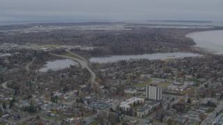 AK0001_0676 - 4K aerial stock footage flying over residential buildings to Westchester Lagoon, Anchorage, Alaska